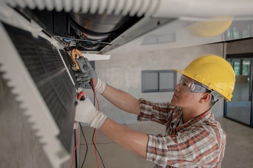 Climatisation Givors - homme qui règle un climatiseur au plafond