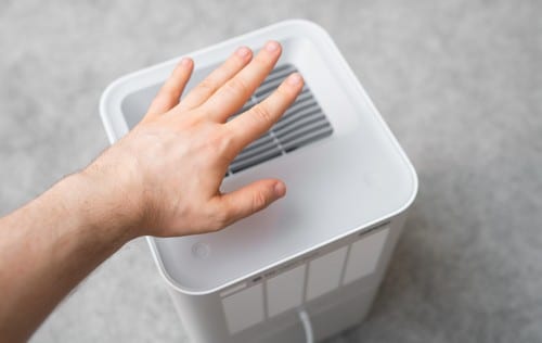 Climatisation Gleize - main posée sur un climatiseur