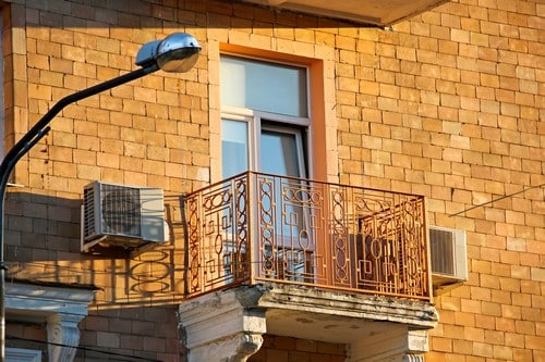 Climatisation L'Arbresle - visuel d'un climatiseur en extérieur à côté d'un balcon