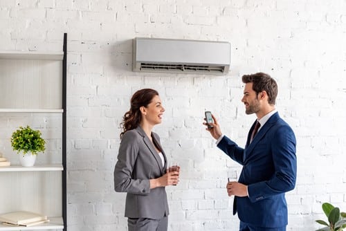 Climatisation Les Pennes Mirabeau - 2 personnes qui discutent en dessous d'un climatiseur