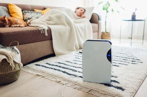 Climatisation Limay - femme allongée sur un canapé devant un climatiseur