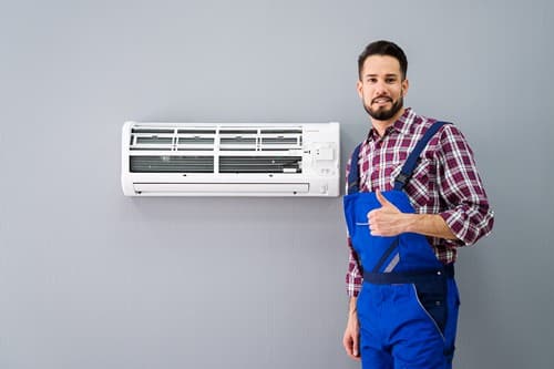 Climatisation Mennecy - homme qui sourit devant un climatiseur après l'avoir installé