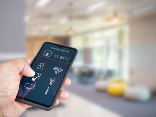 Climatisation Ville-d'Avray - main qui tient un téléphone pour régler la température de la climatisation