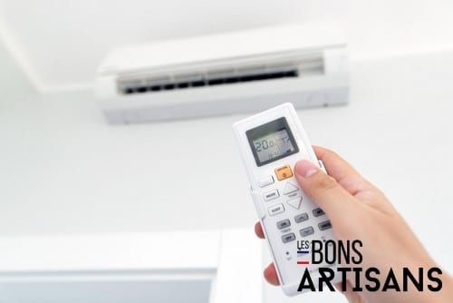 Climatisation Bedarieux - main qui tient une télécommande pour régler un climatiseur au plafond