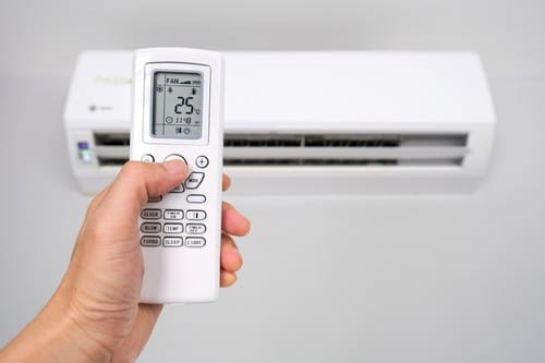 Climatisation Fuveau - main qui tient une télécommande pour régler un climatiseur
