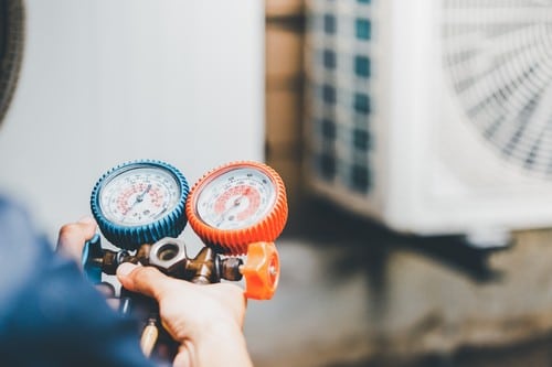 Climatisation La Tour d'Aigues - personne qui tient un appareil pour régler un climatiseur