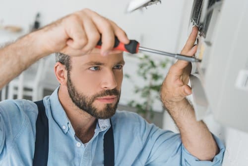 Climatisation Le Pian Médoc - homme qui tient un tourne vice pour régler un climatiseur