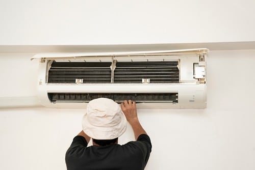 Climatisation Mouans-Sartoux - homme qui règle un climatiseur au plafond