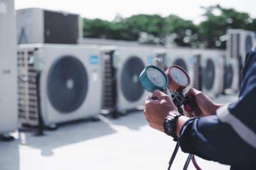 Climatisation Pernes-les-Fontaines - personne qui tient un outil pour régler des climatiseurs