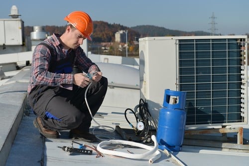 Climatisation Ronchin - homme qui règle un climatiseur sur un toit