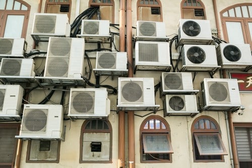 Climatisation Saint-Amand-les-Eaux - visuel de plusieurs climatiseurs sur une façade de bâtiment avec plein de fenêtre