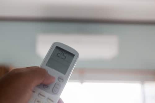 Climatisation Vedène - main qui tient une télécommande pour régler un climatiseur