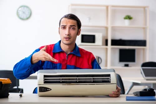 Climatisation Villemur-sur-Tarn - homme qui règle un climatiseur sur une table