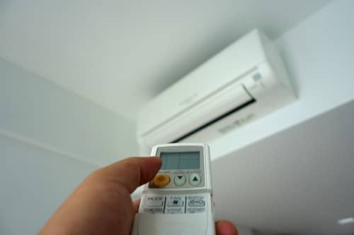 Climatisation Wattignies - main qui tient une télécommande pour régler un climatiseur